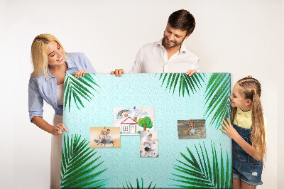 Korktafel mit tropischen Blättern auf blauem Hintergrund