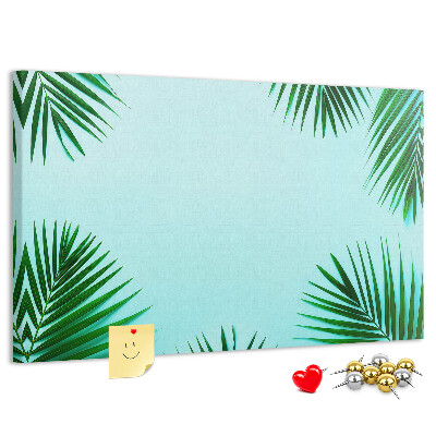 Korktafel mit tropischen Blättern auf blauem Hintergrund