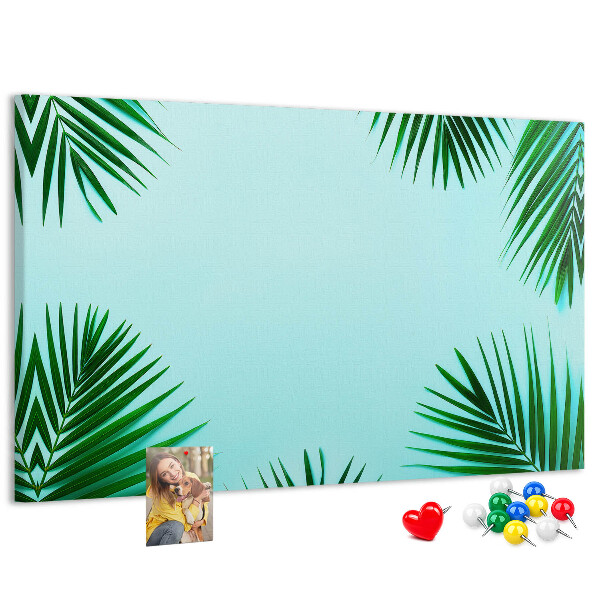 Korktafel mit tropischen Blättern auf blauem Hintergrund