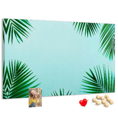 Korktafel mit tropischen Blättern auf blauem Hintergrund