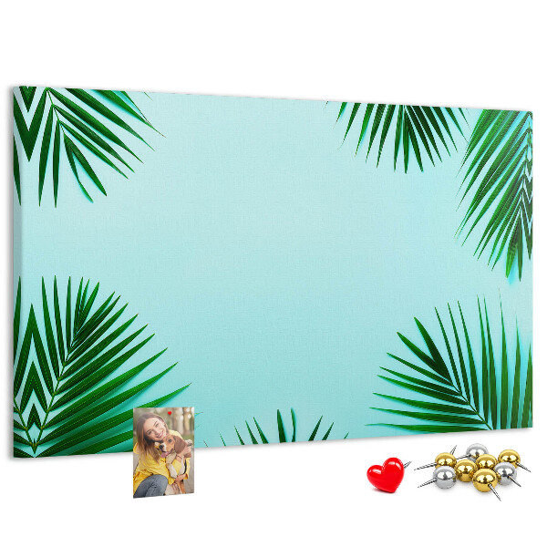 Korktafel mit tropischen Blättern auf blauem Hintergrund