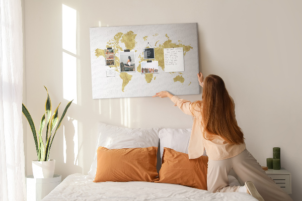 Kork-Pinnwand mit Motiv einer goldenen Weltkarte auf weißem Hintergrund
