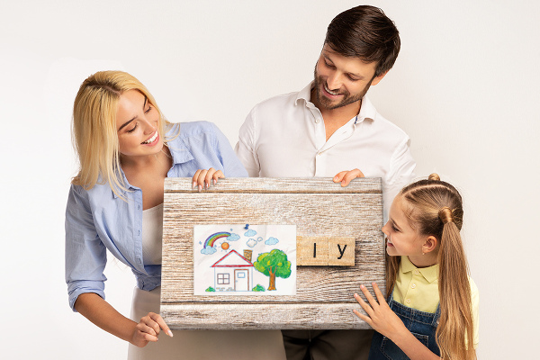 Korktafel mit Motiv einer Familie vor einem Holzbrett
