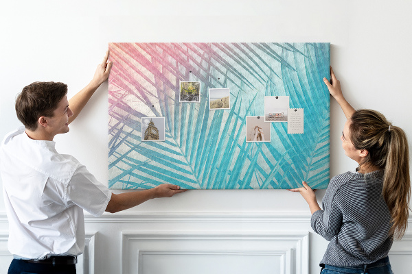 Korktafel mit Motiv tropische Blätter auf pastellfarbenem Hintergrund