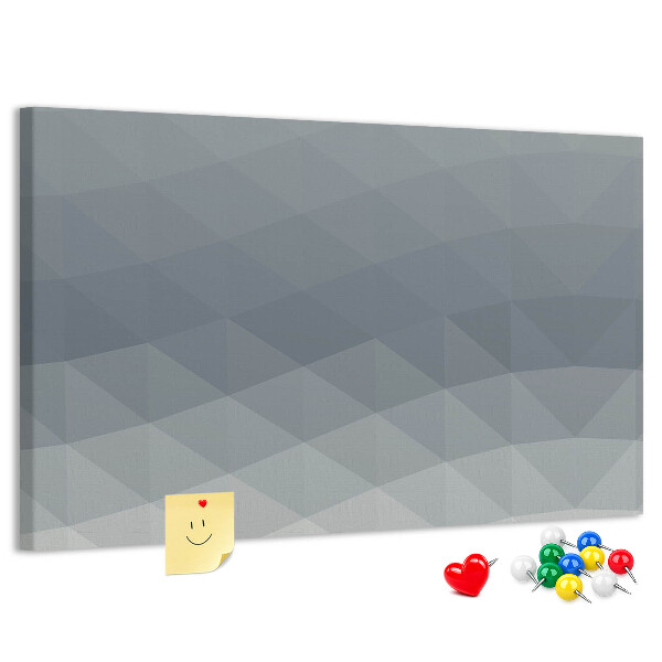 Korktafel mit geometrischen Graustufendreiecken im Hintergrund