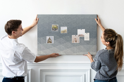 Korktafel mit geometrischen Graustufendreiecken im Hintergrund