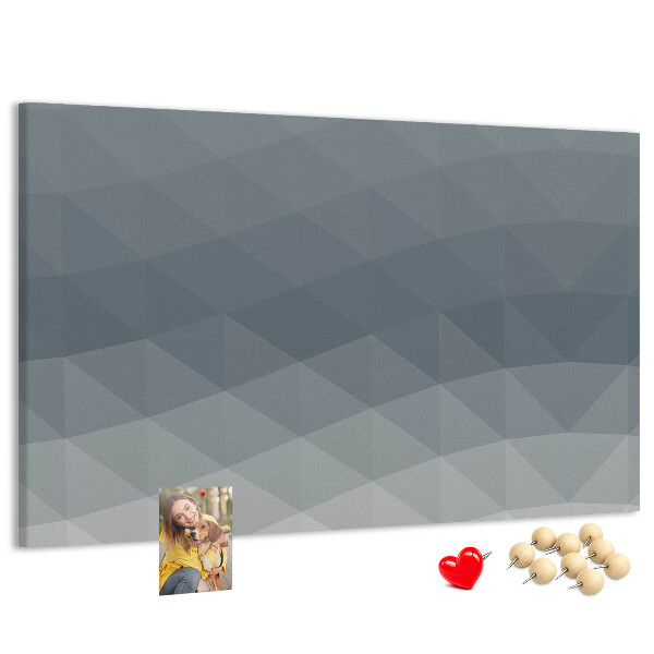 Korktafel mit geometrischen Graustufendreiecken im Hintergrund