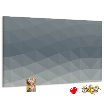 Korktafel mit geometrischen Graustufendreiecken im Hintergrund