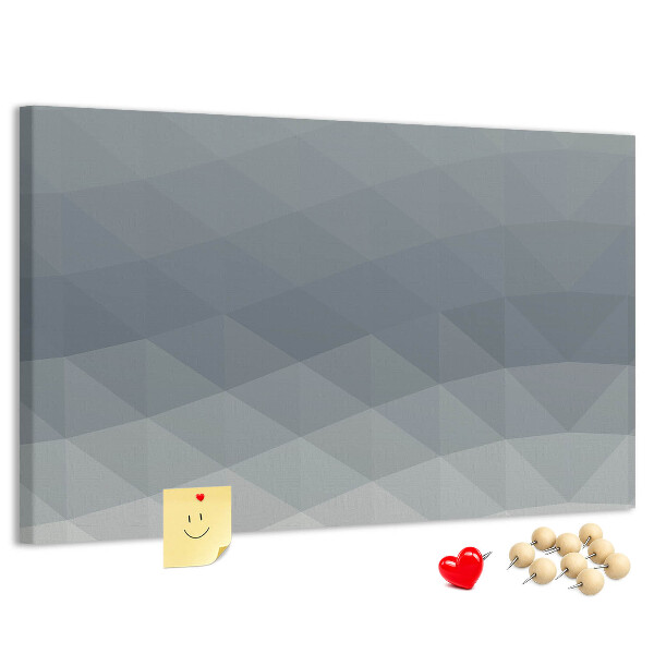 Korktafel mit geometrischen Graustufendreiecken im Hintergrund