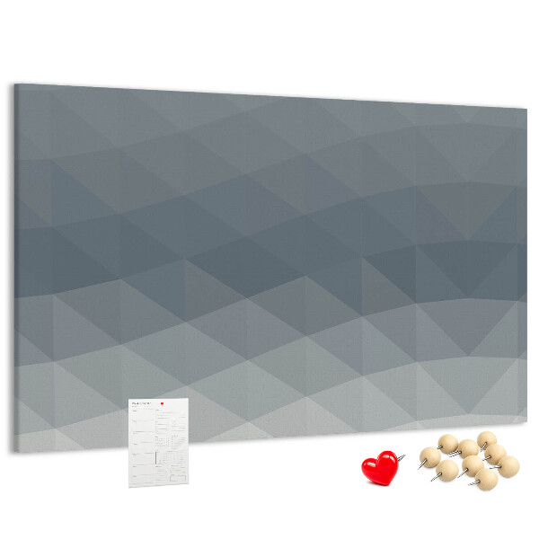 Korktafel mit geometrischen Graustufendreiecken im Hintergrund
