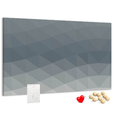 Korktafel mit geometrischen Graustufendreiecken im Hintergrund