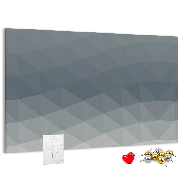 Korktafel mit geometrischen Graustufendreiecken im Hintergrund