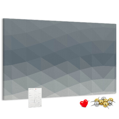 Korktafel mit geometrischen Graustufendreiecken im Hintergrund