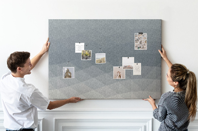 Korktafel mit geometrischen Graustufendreiecken im Hintergrund