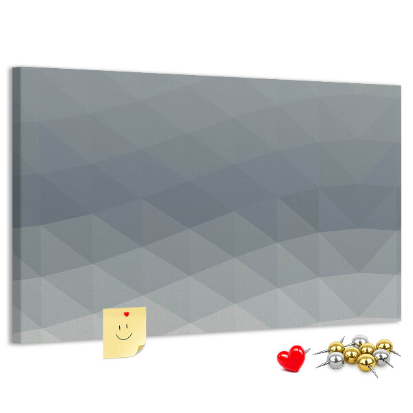 Korktafel mit geometrischen Graustufendreiecken im Hintergrund