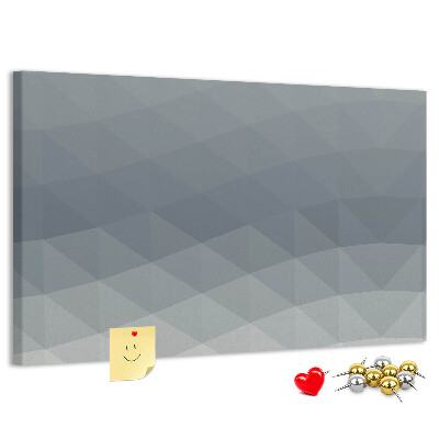 Korktafel mit geometrischen Graustufendreiecken im Hintergrund