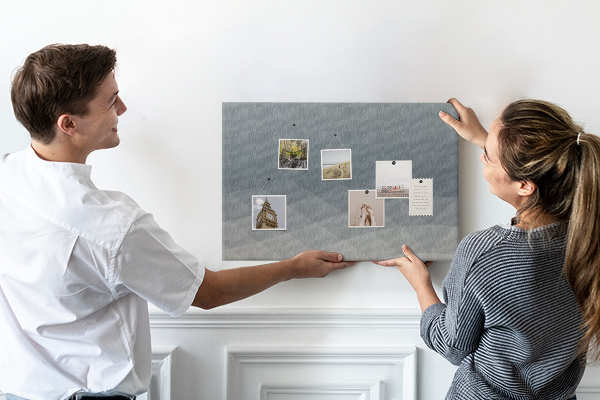 Korktafel mit geometrischen Graustufendreiecken im Hintergrund