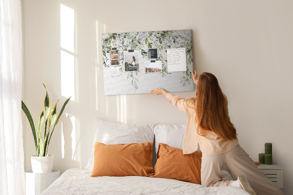 Korktafel mit Motiv aus grünen Blättern und zarten Blüten