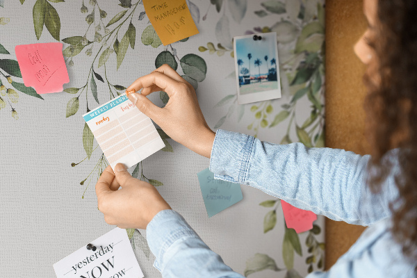 Korktafel mit Motiv aus grünen Blättern und zarten Blüten