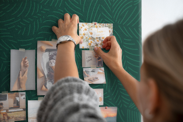 Korktafel mit Motiv grüne Blätter auf dunklem Hintergrund