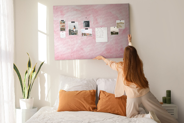 Bild mit Korkrückwand zarte rosa Federn im Hintergrund