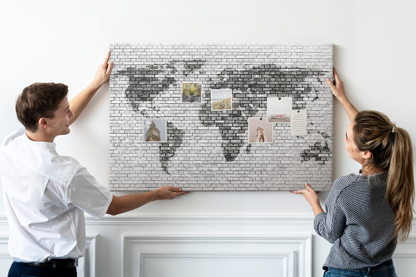 Korkbild Weltkarte an einer Backsteinmauer