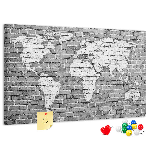 Korktafel mit Motiv Weltkarte an einer Backsteinmauer