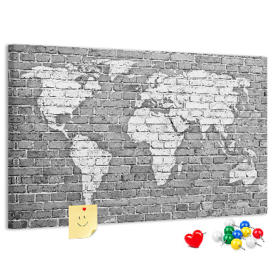 Korktafel mit Motiv Weltkarte an einer Backsteinmauer