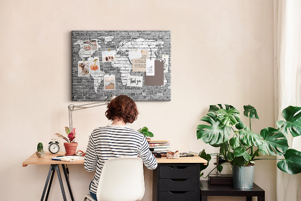 Korktafel mit Motiv Weltkarte an einer Backsteinmauer