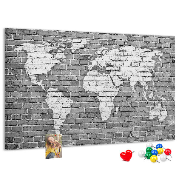 Korktafel mit Motiv Weltkarte an einer Backsteinmauer
