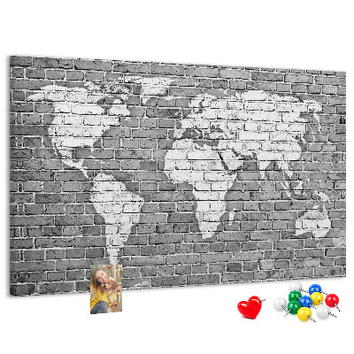 Korktafel mit Motiv Weltkarte an einer Backsteinmauer