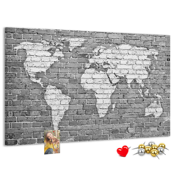 Korktafel mit Motiv Weltkarte an einer Backsteinmauer