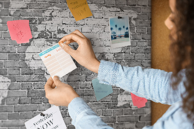 Korktafel mit Motiv Weltkarte an einer Backsteinmauer