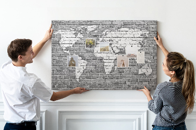 Korktafel mit Motiv Weltkarte an einer Backsteinmauer