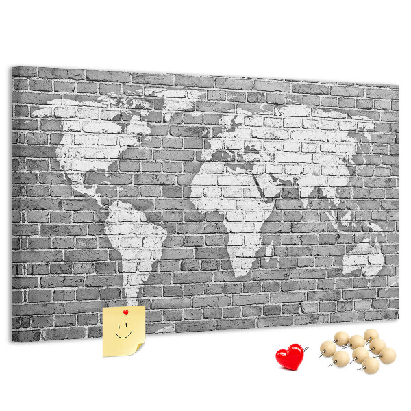 Korktafel mit Motiv Weltkarte an einer Backsteinmauer
