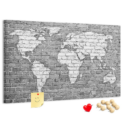 Korktafel mit Motiv Weltkarte an einer Backsteinmauer