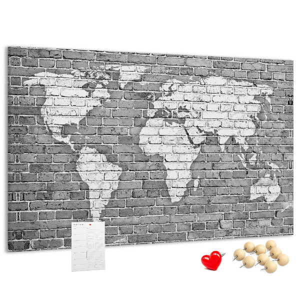Korktafel mit Motiv Weltkarte an einer Backsteinmauer