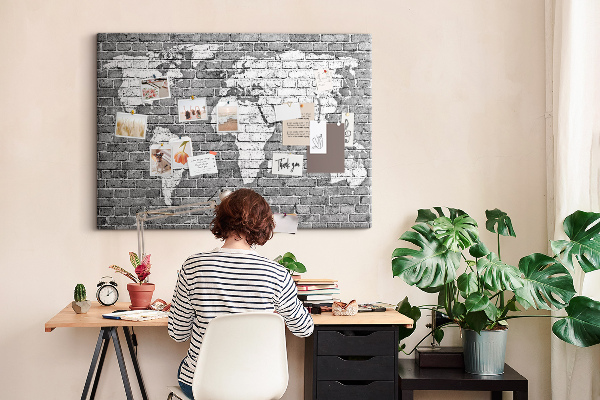 Korktafel mit Motiv Weltkarte an einer Backsteinmauer