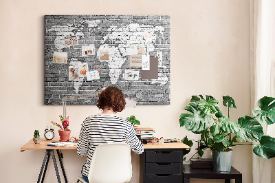 Korktafel mit Motiv Weltkarte an einer Backsteinmauer