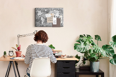 Korktafel mit Motiv Weltkarte an einer Backsteinmauer