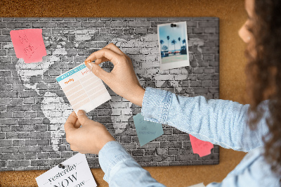 Korktafel mit Motiv Weltkarte an einer Backsteinmauer