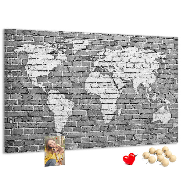 Korktafel mit Motiv Weltkarte an einer Backsteinmauer