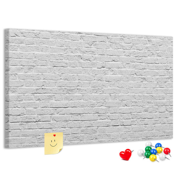 Korktafel mit weißem Backsteinmauer-Motiv und bunten Reißzwecken