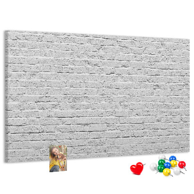 Korktafel mit weißem Backsteinmauer-Motiv und bunten Reißzwecken