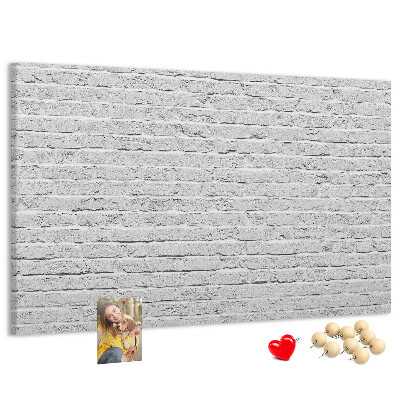 Korktafel mit weißem Backsteinmauer-Motiv und bunten Reißzwecken