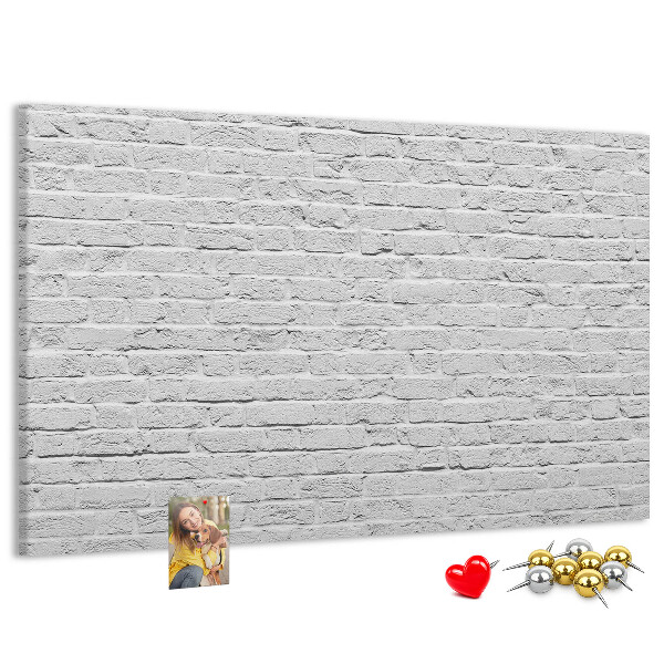 Korktafel mit weißem Backsteinmauer-Motiv und bunten Reißzwecken