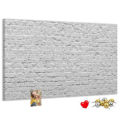 Korktafel mit weißem Backsteinmauer-Motiv und bunten Reißzwecken