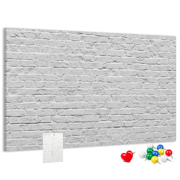 Korktafel mit weißem Backsteinmauer-Motiv und bunten Reißzwecken