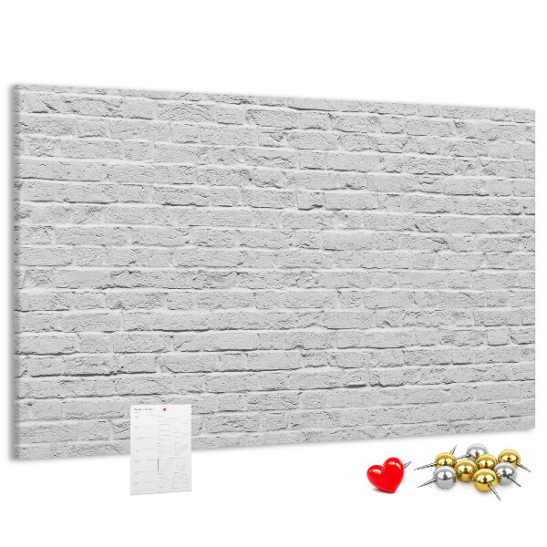 Korktafel mit weißem Backsteinmauer-Motiv und bunten Reißzwecken