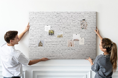 Korktafel mit weißem Backsteinmauer-Motiv und bunten Reißzwecken